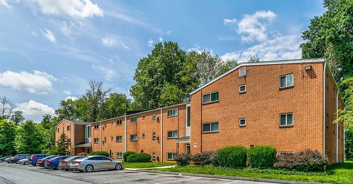 Whitehouse Manor's red-brick apartment buildings surrounded by trees, with off-street parking out front